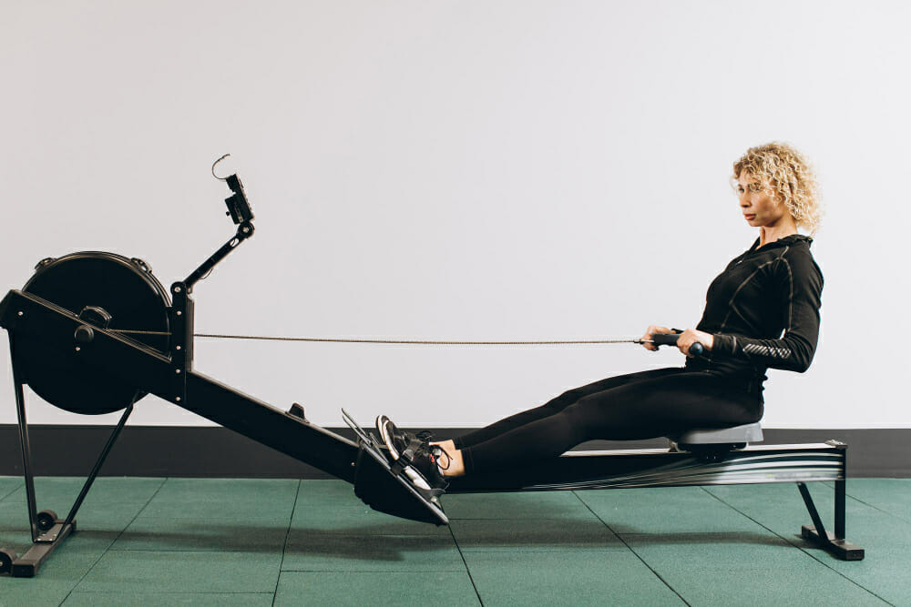 femme pratiquant des exercices de rameur pour maintenir sa forme physique et perdre du poids